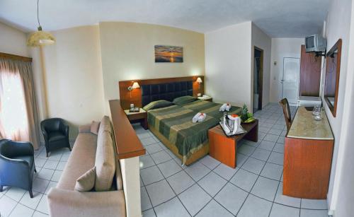 a hotel room with a bed and a living room at Belvedere Aeolis Hotel in Mithymna