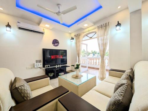 a living room with a couch and a tv at Sapna Homes 4BHK Penthouse, 5min to Beach in Colva