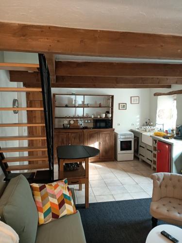 a living room with a table and a kitchen at "Le Coeur de Berrien" Gite familial proche Huelgoat Monts d'Arrée in Berrien