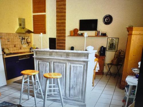 a kitchen with a bar with two stools at Ferienwohnung Danielle Kessler in Idar-Oberstein