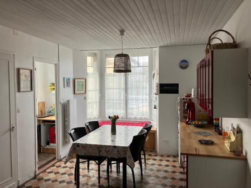 une cuisine avec une table et des chaises dans une pièce dans l'établissement Au Sable d'Or, à Quend-Plage