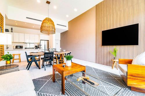 a living room with a couch and a tv on a wall at Casa Lucy Secure-Quiet & Opulent Cabo Retreat-3BR's & Patio! in Cabo San Lucas