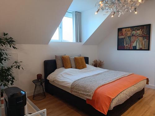 a bedroom with a bed with an orange blanket at B&B Intilia in Kortrijk
