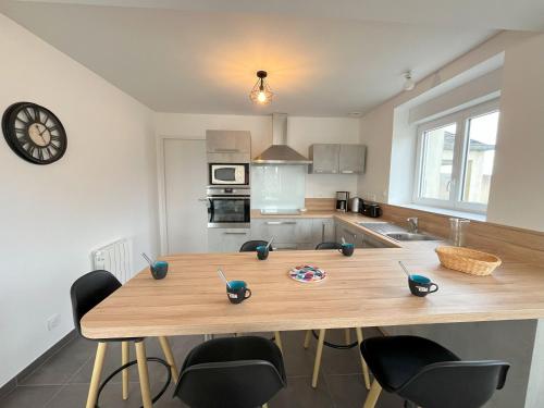 une cuisine avec une table en bois et des chaises. dans l'établissement Maison rénovée 4 chambres, spacieuse pour 8 personnes, à Sibiril