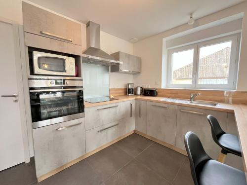 d'une cuisine équipée d'appareils en acier inoxydable et d'un évier. dans l'établissement Maison rénovée 4 chambres, spacieuse pour 8 personnes, à Sibiril