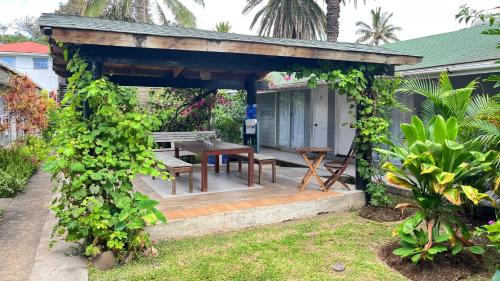 a gazebo with a table and bench in a yard at Inaki Uhi Hotel in Hanga Roa