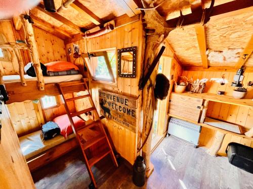 - une vue sur le dessus d'une cabine avec des lits superposés et une échelle dans l'établissement La cabane perchée du trappeur, à Écrainville