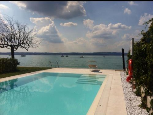 a swimming pool with a view of the water at Super Location front lake in Sirmione