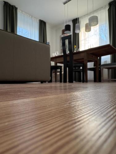 a living room with a wooden floor and a dining table at Historie trifft Moderne in Weikersheim