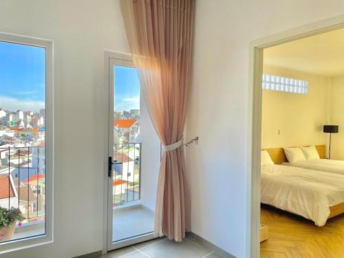 a bedroom with a bed and a large window at Căn Hộ Đan Mây- Đan Mây Apartment Đà Lạt in Da Lat