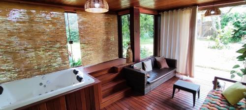 ジャボチカトゥバスにあるPousada trilhas da serraの浴槽とソファのある広いリビングルーム