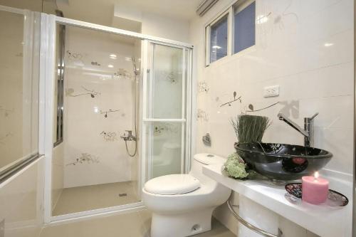 a bathroom with a shower and a toilet and a sink at 宜蘭小綠丘民宿 in Luodong