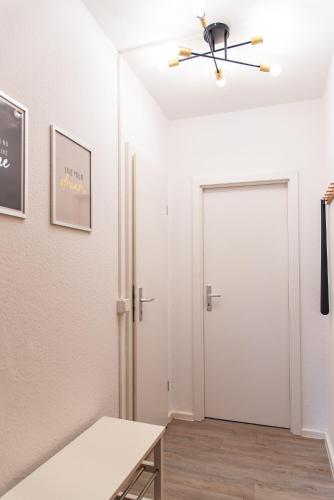 a room with a white door and a ceiling fan at Smart & Cozy Apartment - Balkon, Netflix, Nespresso in Chemnitz