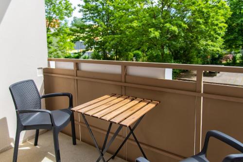 a table and chairs on a balcony with a window at Smart & Cozy Apartment - Balkon, Netflix, Nespresso in Chemnitz