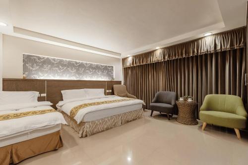 a hotel room with two beds and two chairs at 宜蘭小綠丘民宿 in Luodong