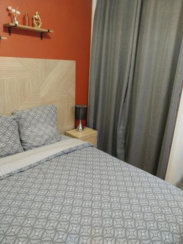 a bedroom with a bed with a gray comforter at T2 Rez de chaussée climatisé jardin parking privé in Balaruc-les-Bains