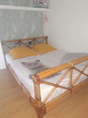 Elle comprend un lit en bois avec des draps blancs et des oreillers jaunes. dans l'établissement La bella vista, à Nice