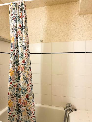 La salle de bains est pourvue d'un rideau de douche et d'une baignoire. dans l'établissement Charmant duplex à Font-Romeu Odeillo Via, à Font-Romeu-Odeillo-Via