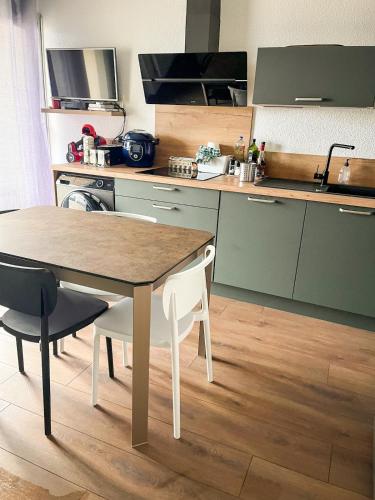 une cuisine avec une table et des chaises dans une cuisine dans l'établissement Charmant duplex à Font-Romeu Odeillo Via, à Font-Romeu-Odeillo-Via