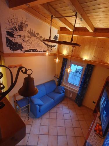 un soggiorno con un divano blu e una TV di casa claudio-APPARTAMENTI IN CENTRO a Campitello di Fassa