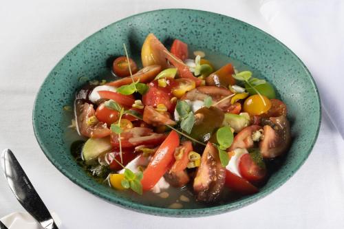 a green bowl of food with meat and vegetables at Hotel & Thalasso Villa Antilla - Habitaciones con Terraza - Thalasso incluida in Orio