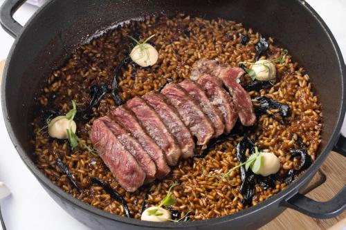 a pan full of food with meat and rice at Hotel & Thalasso Villa Antilla - Habitaciones con Terraza - Thalasso incluida in Orio
