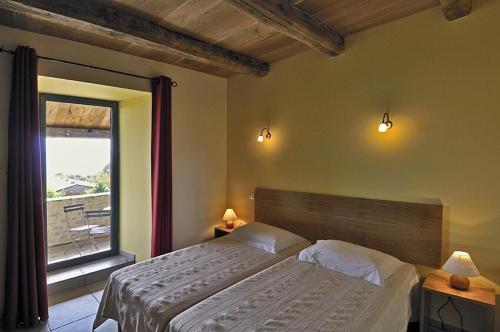 une chambre avec un lit et une grande fenêtre dans l'établissement Gîte de Caractère la Grange, à Buzeins