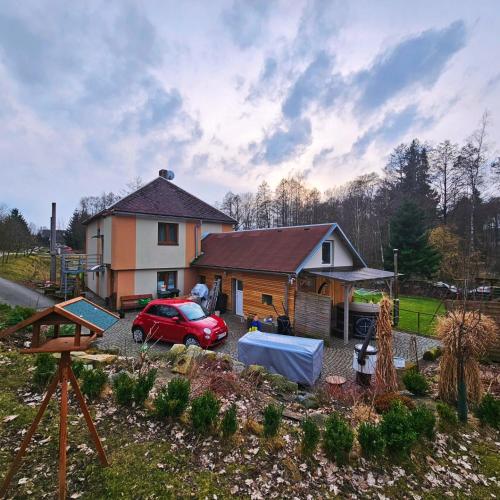 a house with a red car parked in front of it at Farma u lesa in Hlinsko