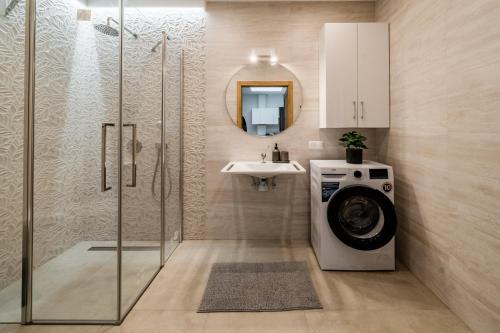 a bathroom with a washing machine and a sink at Apartament Park Zdrojowy 11 - NOWOŚĆ in Rabka