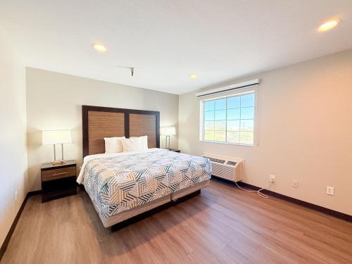 a large bedroom with a bed and a window at Studio 6 Suites Tucson, AZ Airport Kino Sports Complex in Tucson