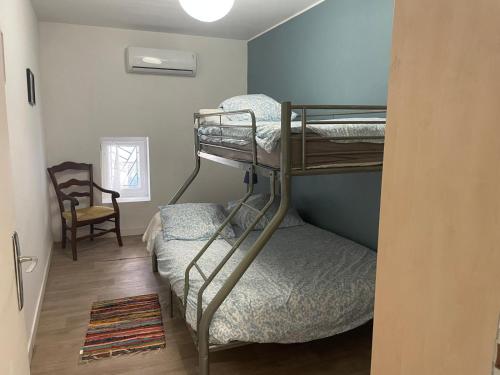 Cette chambre comprend 2 lits superposés et une chaise. dans l'établissement Le Careyrou, à Paziols