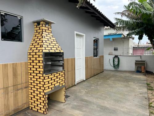 a brick oven in the side of a house at Casa Imbituba proximo lagoa e praia in Imbituba