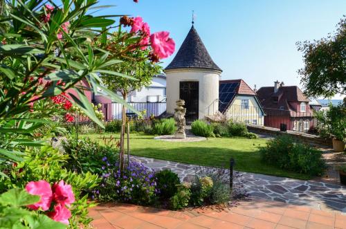 a home with a garden with flowers and a turret at Ferienwohnung Turmblick in Stein an der Donau
