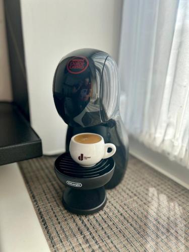 a coffee maker with a cup on top of it at Fashion Apartment in Narva