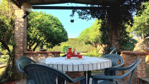 a table with chairs and a red vase on it at Da Ninnilla Holiday Home Scafati in Scafati