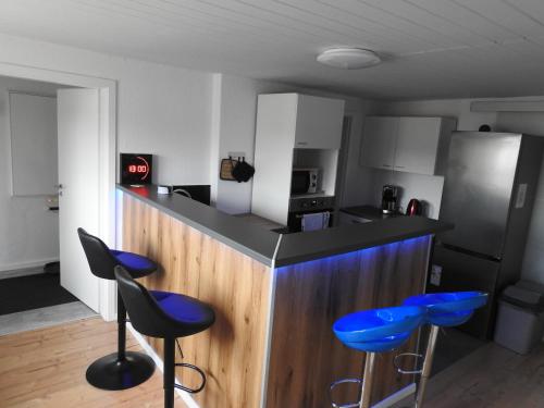 a kitchen with blue stools at a counter at Alte Schmiede in Rathenow