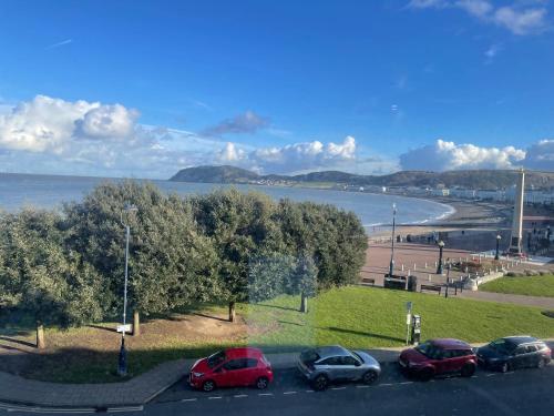 a group of cars parked in a parking lot near a beach at The Wildings Hotel & Tudno's Restaurant in Llandudno