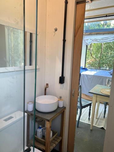 a bathroom with a sink and a table and a window at Tree House in Balneário Camboriú