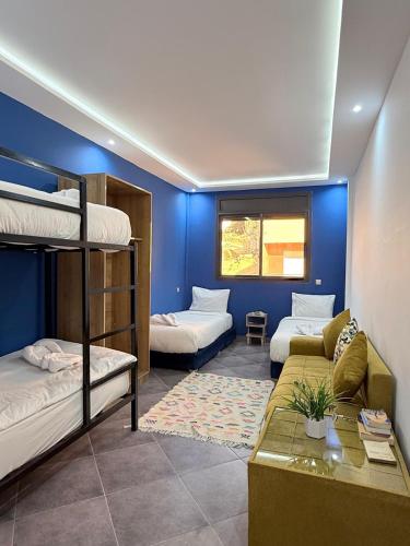 a room with two bunk beds and a couch at Playa Surf House in Tamraght Ouzdar