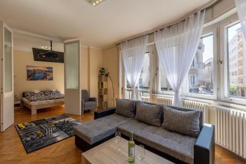 een woonkamer met een bank en een groot raam bij Best Location, Family friendly Panorama view by NeWave in Boedapest