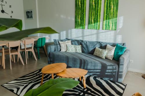 a living room with a blue couch and a table at Comfort Zone beach apartment in Quarteira