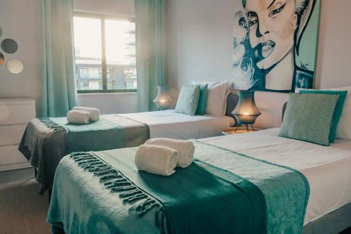 a room with three beds with towels on them at Comfort Zone beach apartment in Quarteira