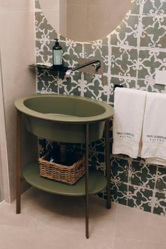 a green sink in a bathroom with a wall at San Lorenzo Suites in Putignano