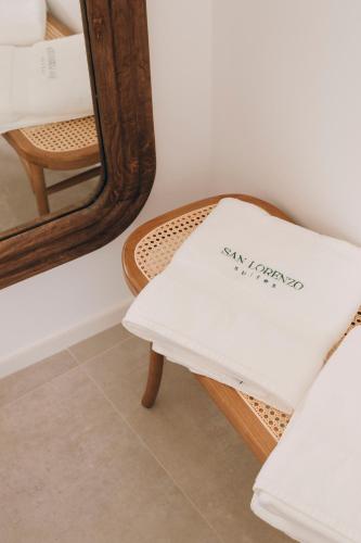 a mirror and a chair with a white pillow at San Lorenzo Suites in Putignano