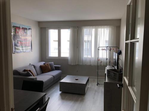 un salon avec un canapé et une table dans l'établissement T2 avec parking La Rochelle, à La Rochelle