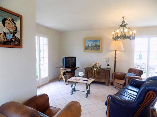 un salon avec un canapé, des chaises et une télévision dans l'établissement Saint Georges de Didonne - MAISON de CARACTERE avec GRAND JARDIN - excentré, à Saint-Georges-de-Didonne