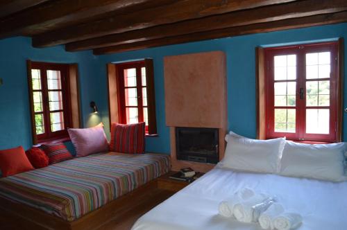 a bedroom with two beds and a couch and windows at Anemi in Kato Pedina