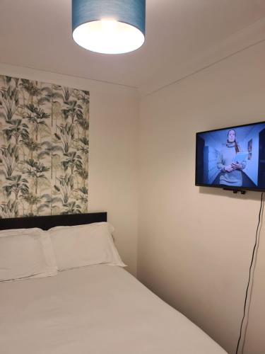 a bedroom with a bed and a flat screen tv on the wall at Two bedrooms Modern Home in Middlesbrough