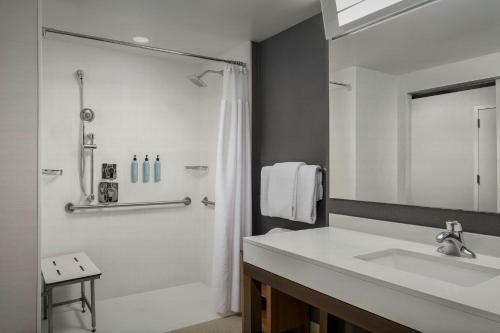 a white bathroom with a sink and a shower at Courtyard by Marriott Muncie at Horizon Convention Center in Muncie