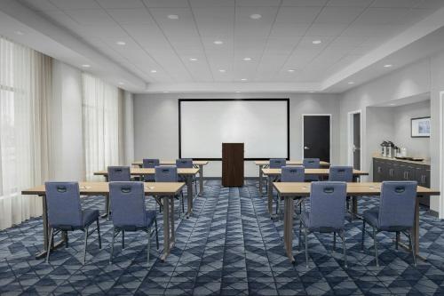 a conference room with tables and chairs and a projection screen at Courtyard by Marriott Muncie at Horizon Convention Center in Muncie